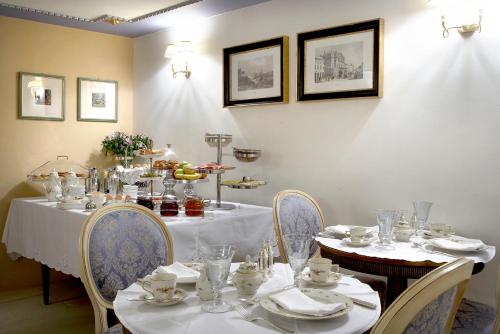 纳弗帕克托斯阿宏提可皮普斯酒店的用餐室配有桌椅、盘子和玻璃杯