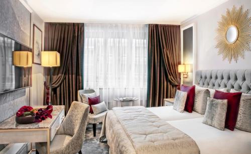 日内瓦皇家玛诺特酒店的酒店客房设有一张大床和一张沙发。
