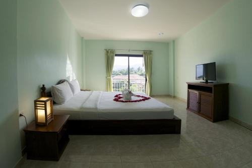查汶PTK公寓酒店的一间卧室配有一张大床和电视