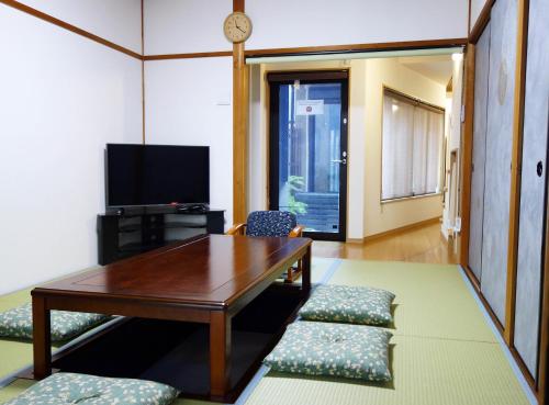 京都东寺君子之家公寓的客厅配有桌椅和电视。