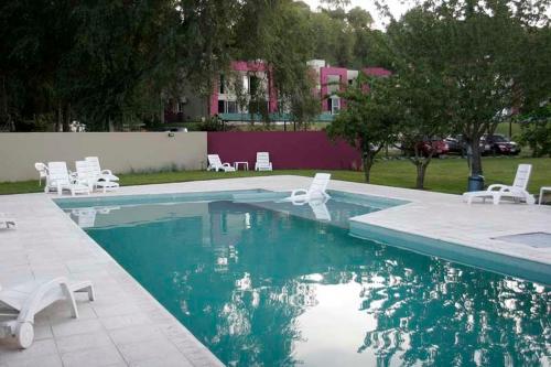塞拉德洛斯帕德雷斯Hotel Sierra de los Padres的一个带白色躺椅的游泳池和一个游泳池