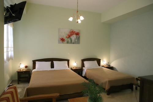 阿里奥波利斯玛尼酒店的配有两张床铺的房间,桌子上放着两盏灯