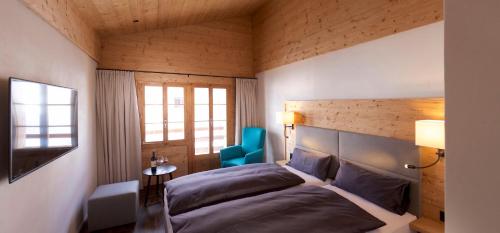 布赖尔Adults Only Hotel Mulin - Das Erwachsenen-Hotel in den Bergen的一间卧室配有一张床和一张蓝色椅子