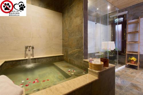 埔里月牙庄休闲度假山庄的浴室设有按摩浴缸,内配红胡椒