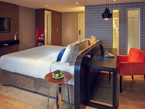 巴西利亚巴西利亚艾克索美爵酒店的配有一张床、一张桌子和一张桌子的酒店客房