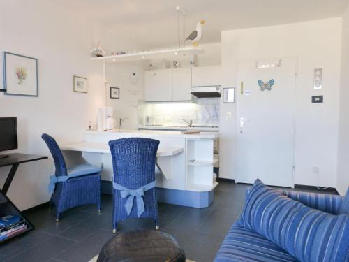 维滕Ferienwohnung *Mein Meerblick*的厨房配有蓝色的椅子、桌子和柜台