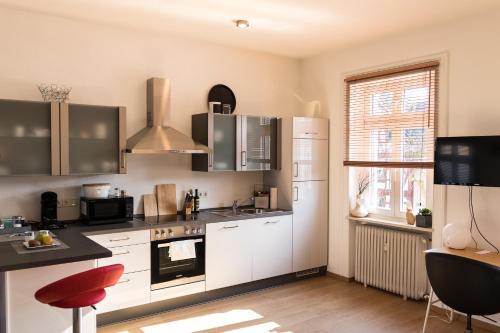 拉恩河畔林堡Loft Apartment Limburg的一间厨房,配有白色家电和红色凳子