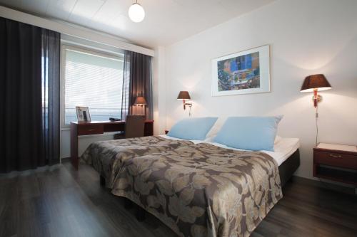 于韦斯屈莱米尔顿酒店的一间卧室配有一张床、一张书桌和一个窗户。