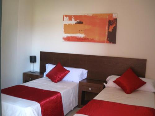 CorveraCorvera Golf and Country Club的一间卧室配有两张带红色枕头的床