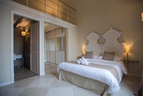 莱切Palazzo Belsanti的卧室配有一张白色大床,上面有两只填充动物