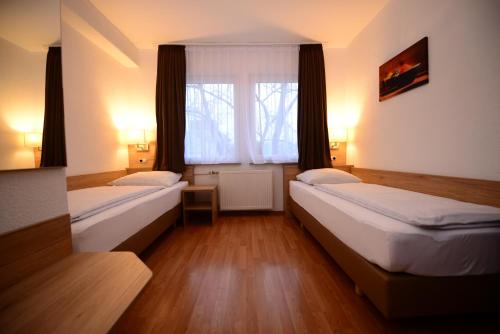 斯图加特林德斯图加特酒店的带窗户的客房内的两张床