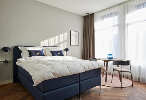 海牙海牙皮斯塔切公寓式酒店的一间卧室配有一张床、一张桌子和一个窗户。
