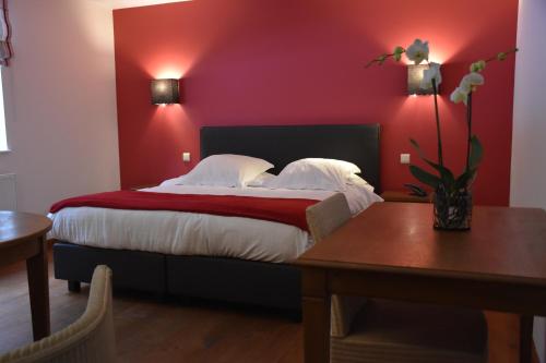 Laforêt莫林西蒙尼斯酒店的一间卧室设有一张红色墙壁的大床