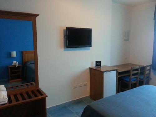 安齐奥塞尔帕酒店的客房设有一张床、一张桌子和一台墙上的电视