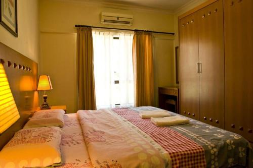 哥打京那巴鲁滨海码头公寓酒店的一间卧室配有一张床,上面有两条毛巾