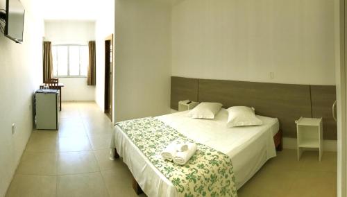 皮涅拉Hotel Pousada Santos的一间卧室配有一张床,上面有两条毛巾