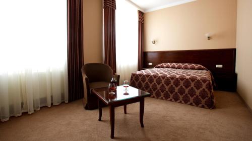 蒂拉斯波尔城市俱乐部酒店 的酒店客房,配有床、桌子和椅子