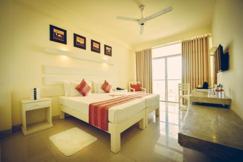 尼甘布Beacon Beach Hotel Negombo的卧室设有一张白色大床和一扇窗户。