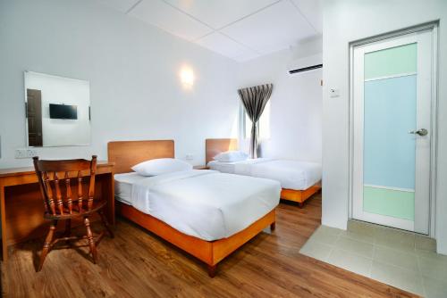 丰盛港MG酒店的一间卧室配有两张床、一张桌子和一把椅子