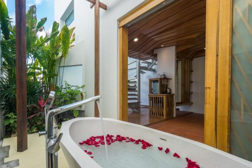 拉迈白沙岛度假酒店的浴室内装有红色鲜花的浴缸