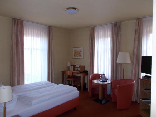勒鲍甜蜜喷泉山地旅馆的酒店客房带一张床、一张桌子和椅子