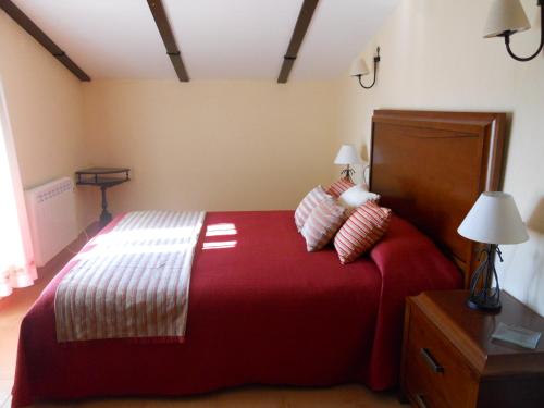 马尔莫莱霍La Aragonesa的一间卧室配有一张红色大床和两个枕头