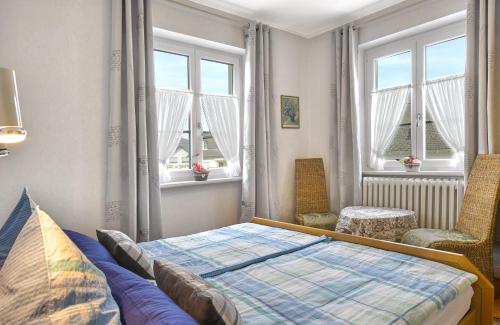 布罗登巴赫Pension "Haus am Walde" Brodenbach, Mosel的一间卧室配有一张床、一把椅子和窗户。