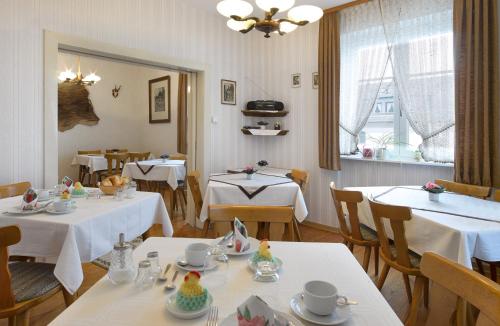 布罗登巴赫Pension "Haus am Walde" Brodenbach, Mosel的餐厅配有桌椅和白色的桌布