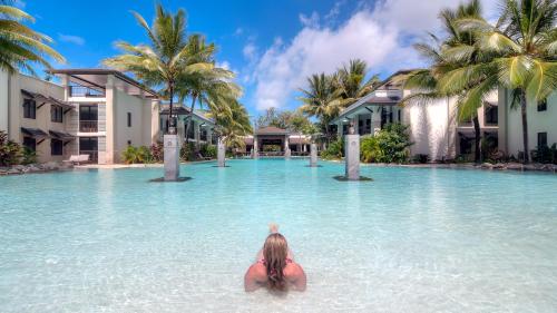 道格拉斯港Luxury Apartments at Temple Resort and Spa Port Douglas的度假胜地的水中的一个女人