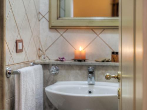 卡塔尼亚Hotel Manganelli Palace的一个带水槽和架子上的蜡烛的浴室
