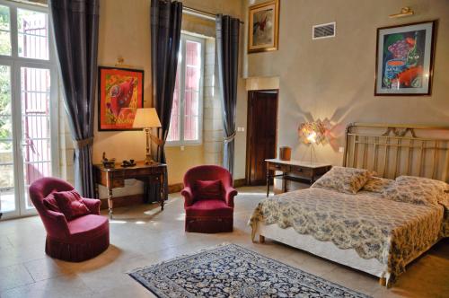 艾马尔格大马尔赫布地区酒店的一间卧室配有一张床和两把椅子