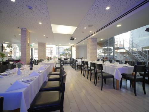 内坦亚马格亚内坦亚酒店的用餐室配有白色桌子和黑色椅子
