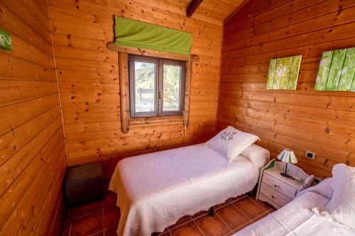 塔里法Rural Tarifa Beach Las Cabañas的小木屋内一间卧室,配有一张床和一个窗户