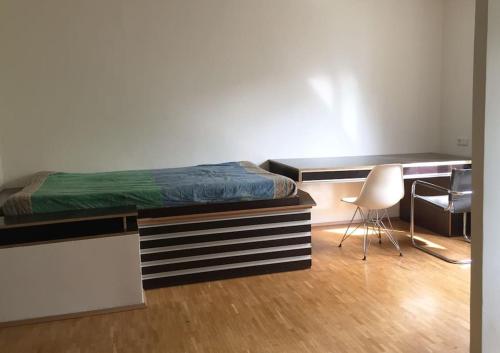维也纳Room in maisonette with garden, parking place的一间卧室配有一张床、一张桌子和一把椅子