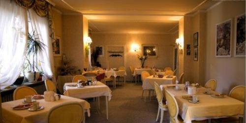 施派尔克尔法尔兹酒店的餐厅设有白色的桌子和黄色的椅子以及白色的桌子。
