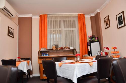 布加勒斯特摩纳哥精品酒店的一间带桌椅和窗户的用餐室