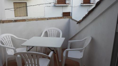 卡索拉Alojamiento rural La Casilla的一张桌子和椅子,坐在墙上,窗户旁