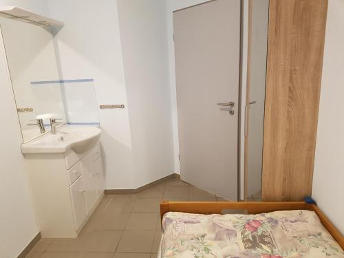 戈赫Hostel Gästehaus zum Padre的一间白色的小浴室,配有水槽和一张床