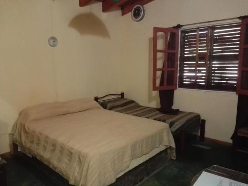 圣奥古斯汀镇Parador La Rosita的一间卧室设有两张床和窗户。