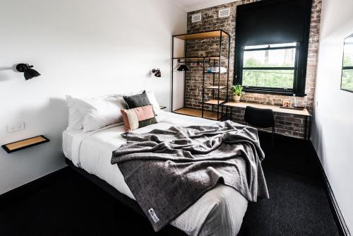 悉尼悉尼公园酒店 的一间卧室设有一张床和砖墙