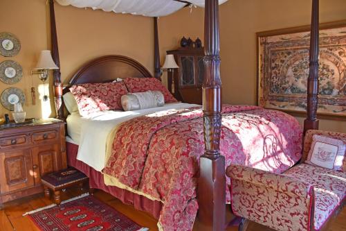 滨湖尼亚加拉苹果树历史住宿加早餐酒店的一间卧室配有一张大床和一把椅子