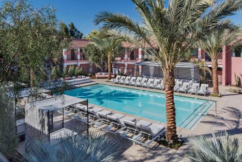 印第安维尔斯金沙温泉酒店 的一个带躺椅的游泳池,并种植了棕榈树