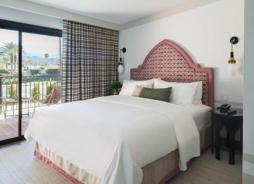 印第安维尔斯金沙温泉酒店 的一间带一张白色大床的卧室和一个阳台