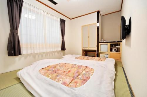 带广Hotel Paco Obihiro Ekimae的一间卧室设有两张床和窗户。