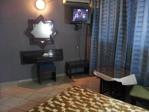 纳祖尔希拉尔达塔酒店的一间卧室配有一张床、一台电视和一张桌子