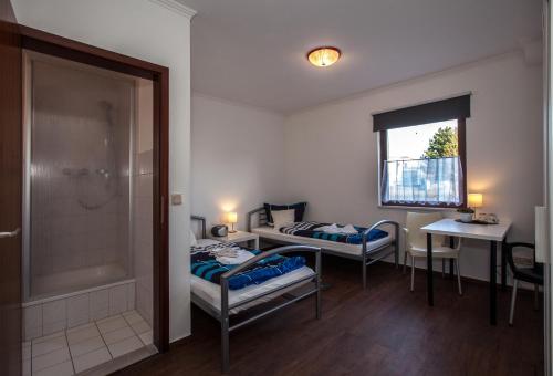 新勃兰登堡Pension ,,Vier Tore''的小房间设有两张床和淋浴