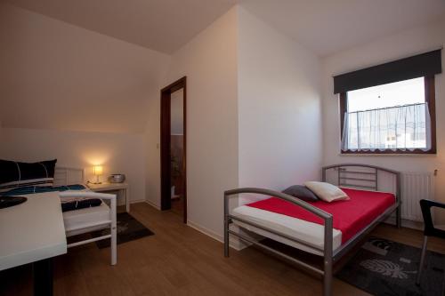 新勃兰登堡Pension ,,Vier Tore''的一间卧室设有两张床、一张桌子和一个窗口