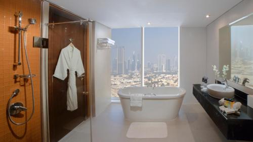 迪拜Millennium Central Downtown的浴室配有卫生间、盥洗盆和淋浴。