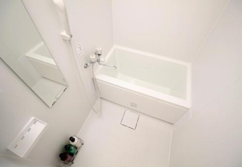 东京新大久保石亭酒店的白色的浴室设有水槽和镜子