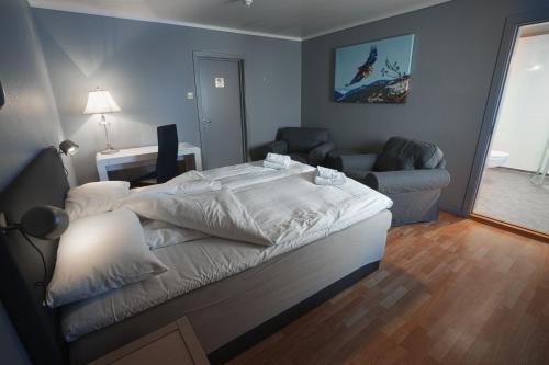 HamremoenKroderen Kro & motel AS的一间卧室配有一张大床和一张沙发